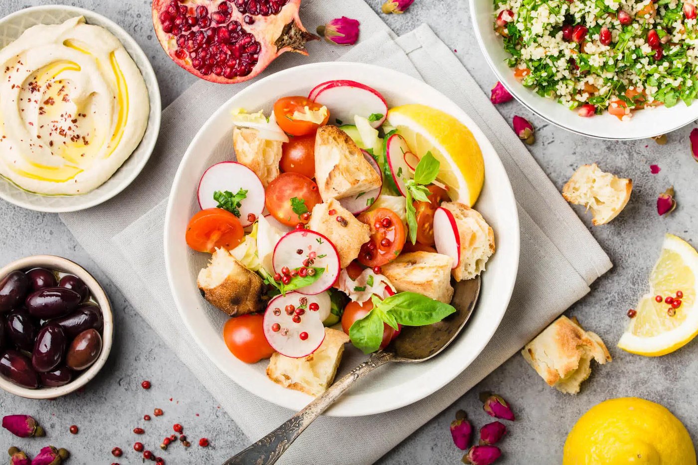 A Mediterranean spread of tomato dishes, olives, dips and flatbread